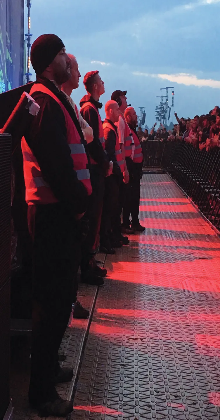 Sicherheitskräfte im Bühnengraben vor dem Publikum