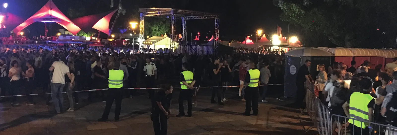 Festivalgelände bei Nacht mit Sicherheitskräften